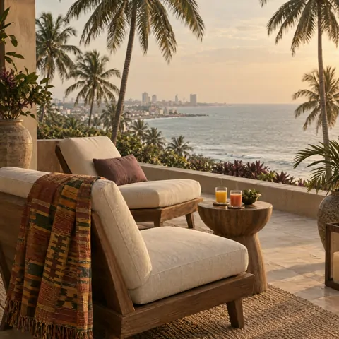 A calm hotel terrace with a woven kente throw and the sea beyond